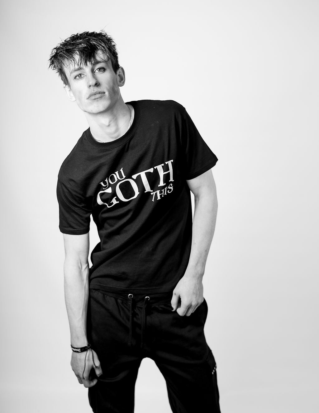 A person wearing a black T-shirt with 'YOU GOTHIS' written on it in white letters.
