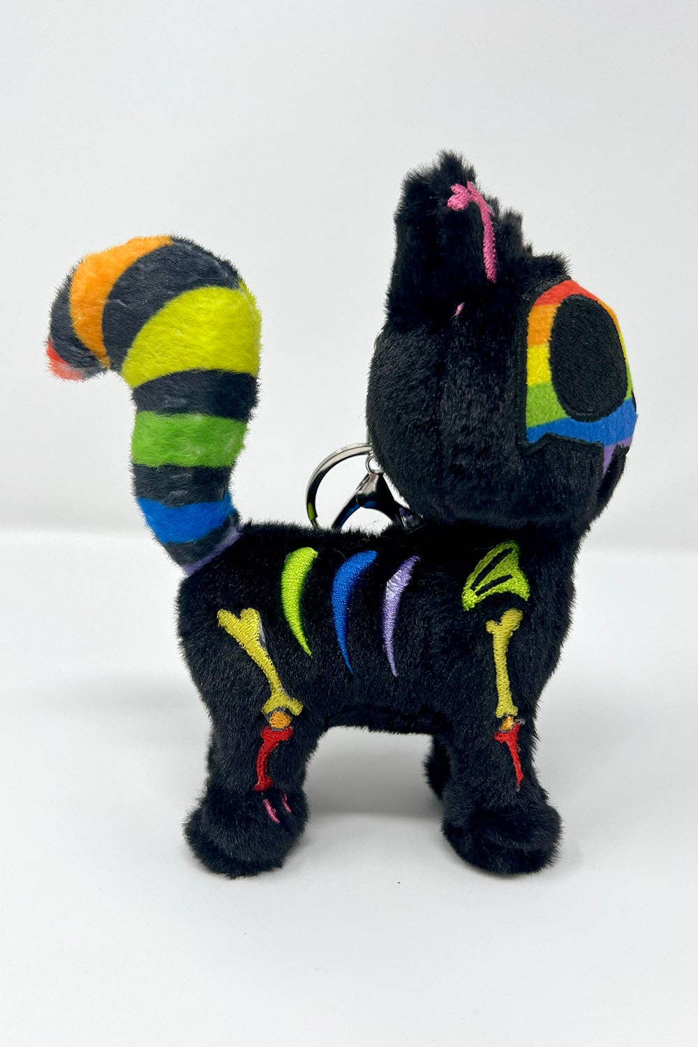 A black plush cat keychain with colorful embroidered details and a striped tail, shown on a plain white background.