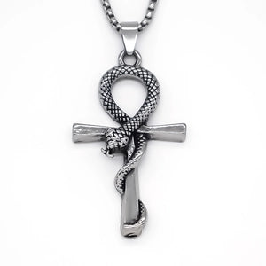 A silver-toned metal pendant necklace featuring an ankh symbol with a coiled snake wrapping through it, suspended from a matching chain against a plain white background.