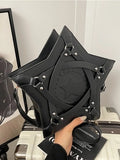A black star-shaped leather handbag with silver rivets and a central star emblem, held by a hand over a light-colored suitcase.