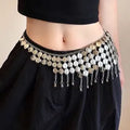 A close-up of a model's waist wearing a black hip scarf or belly dance skirt adorned with a wide, ornate silver coin belt featuring dangling chains and coin embellishments.